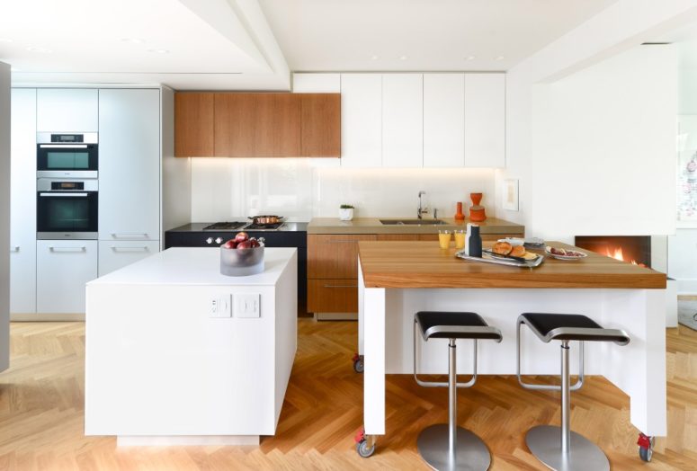 The kitchen is done with maximal functionality and the mix of wood and white surfaces are a chic modern idea The kitchen is done with maximal functionality and the mix of wood and white surfaces are a chic modern idea