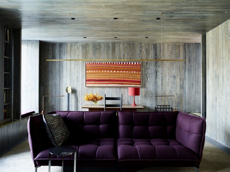 Here's another living room with an integrated workspace, almost fully clad with natural textural wood