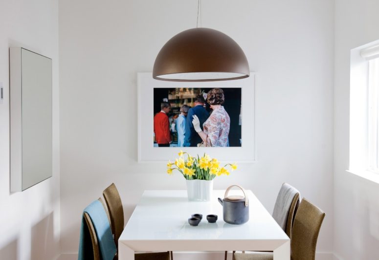 artwork near a dining space The dining zone features a comfy area for four people and an artwork plus a stylish pendant lamp