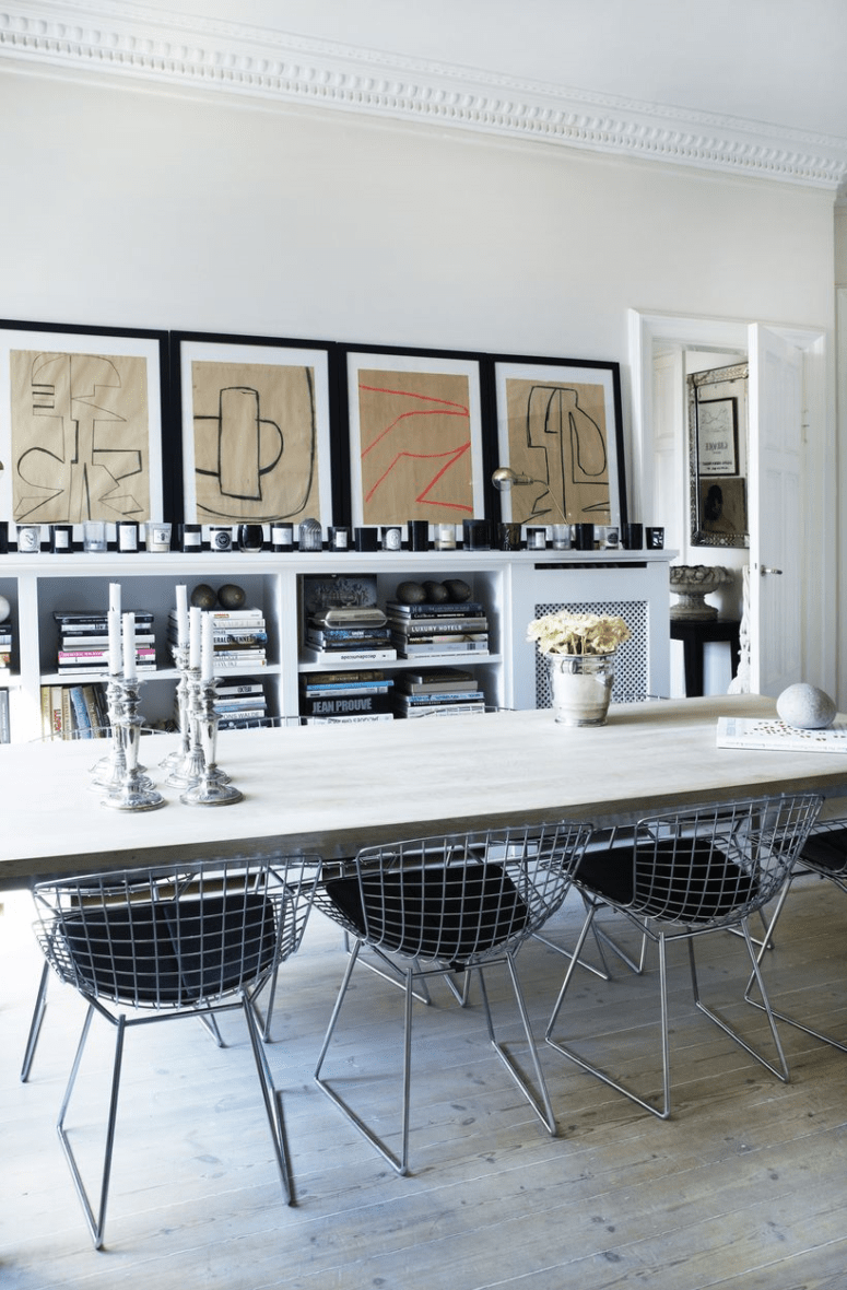 The dining room is done with a wooden table, metal chairs, a storage piece and a gallery wall