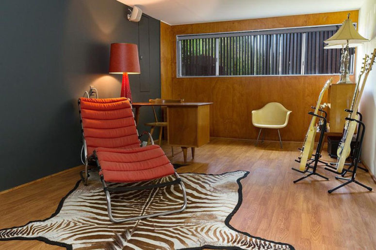 The home office is done in graphite grey and with plywood, with red touches and a faux zebra skin rug The home office is done in graphite grey and with plywood, with red touches and a faux zebra skin rug