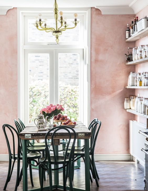 a countryside dining space with pink Venetian plaster walls and a brass chandelier