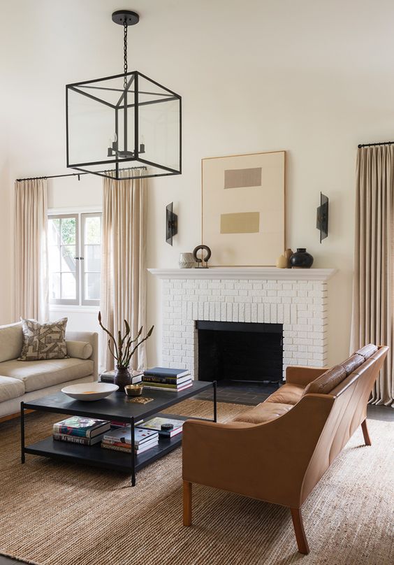 an elegant living room done in the sahdes of beige and camel plus black details for depth