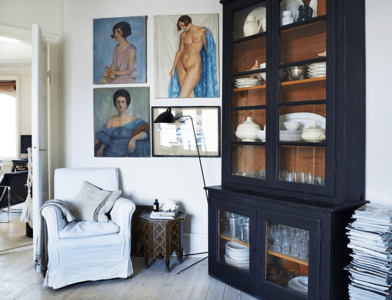 The black armoire is a vintage French piece and colorful art contrasts it