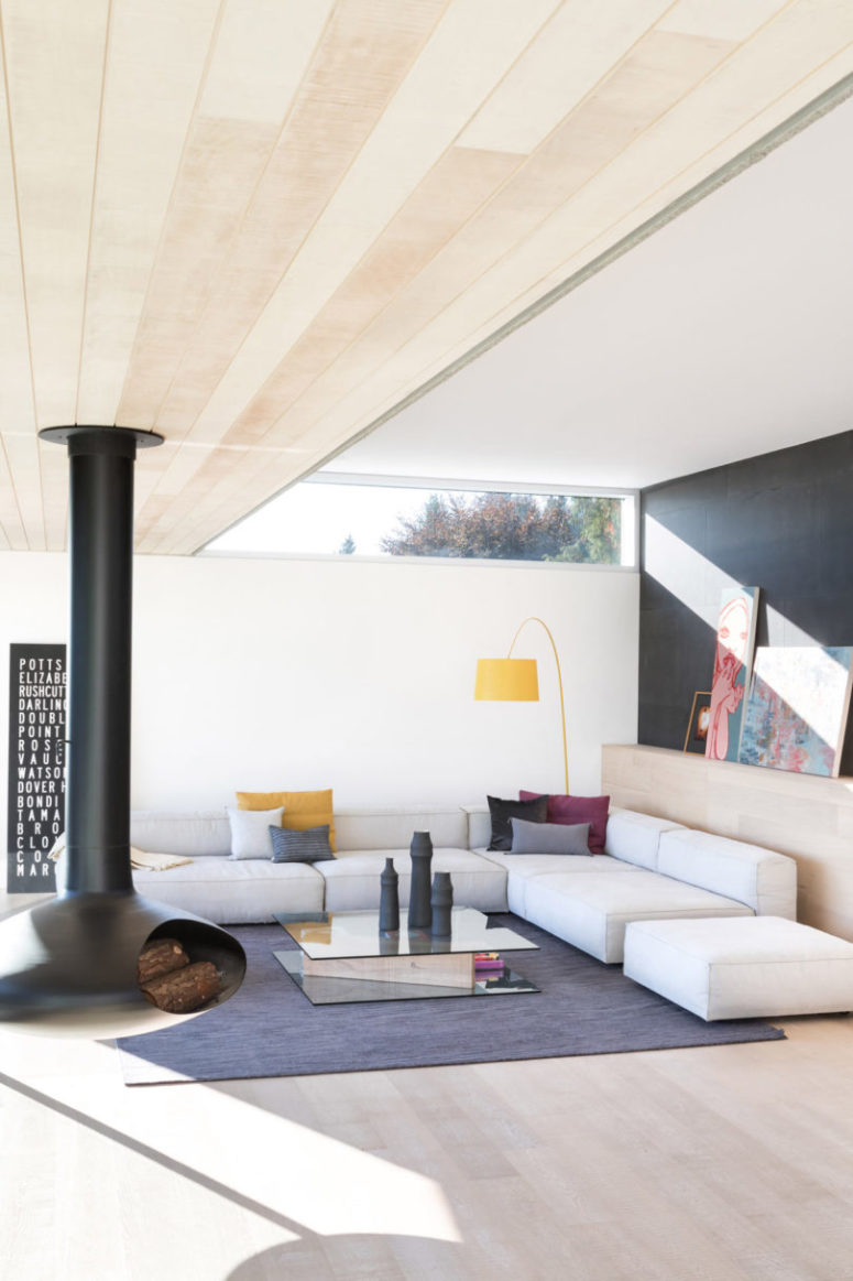living room with a sectional sofa The living room features a corner sofa, a glass coffee table, a hanging hearth and some colorful touches
