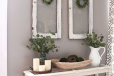 08 a vintage console with moss balls, eucalyptus, candles and vintage windows with greenery wreaths