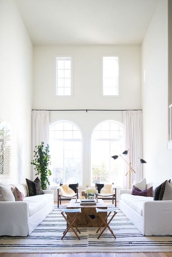 the whole living room done in white and ivory and colorufl pillows and rugs spruce it up
