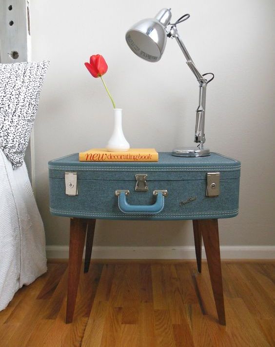 a vintage suitcase reupholstered and put on legs to create a cool nightstand