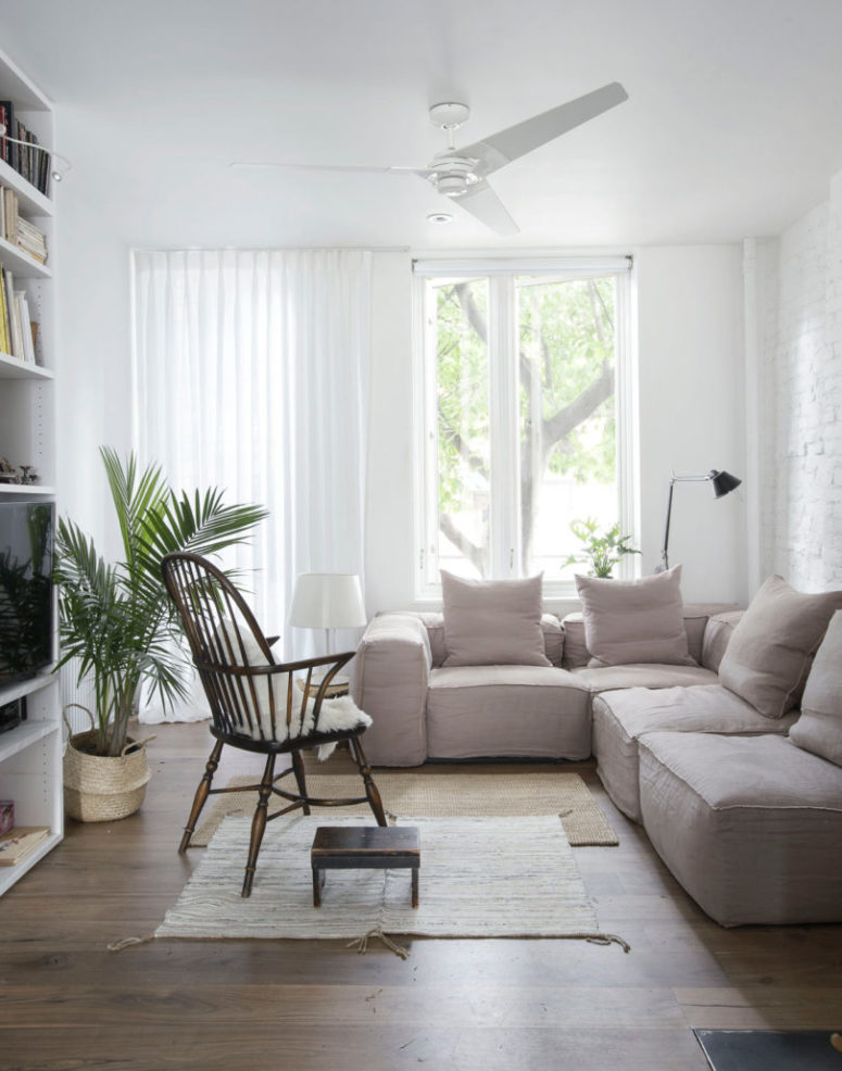 The living room is done with an L-shaped sofa, shelves and some vitnage furniture finds plus rugs
