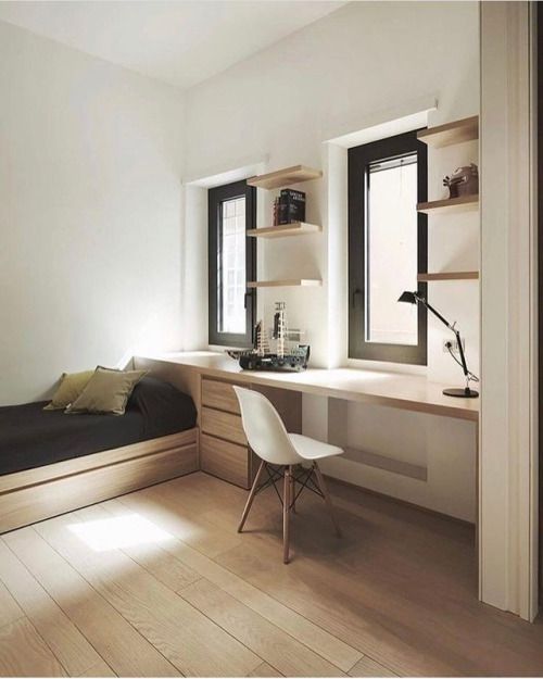 a minimalist guest bedroom with a bed and a desk by the window is done flawless and seamless