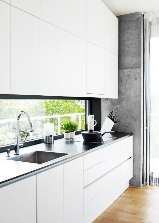 a minimalist white kitchen with a black framed window backsplash for a more catch and peaceful look