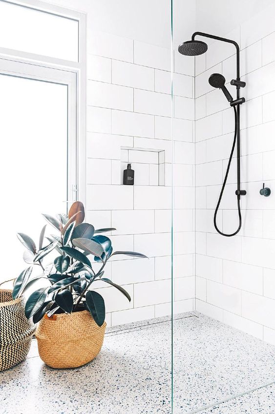 a tall window placed on the side and with potted plants to make the shower more private
