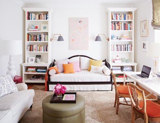 a guest bedroom with two convertible sofas as sleeping spaces and a shared home office by the window