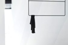 15 a minimalist black rack with two shelves attached to the ceiling for a Scandinavian space