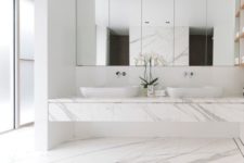 15 white marble, a large mirror, a large marble vanity and frosted glass windows for a spa feel