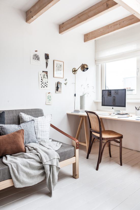 a serene and airy guest bedroom with a comfy sofa for sleeping and a desk by the window