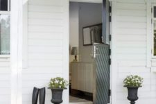 21 a black striped Dutch door is a bold contrasting touch for a white house