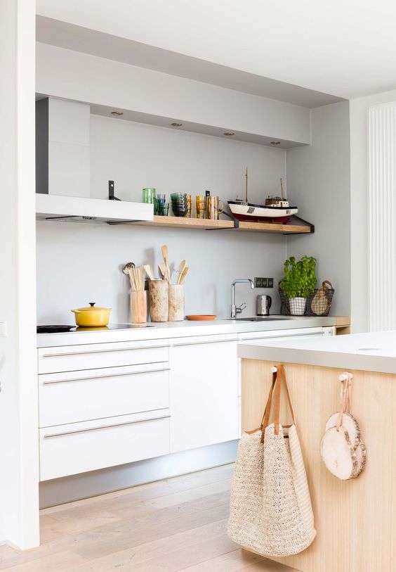 a niche kitchen with a grey plaster wall that brings texture and interest to the space