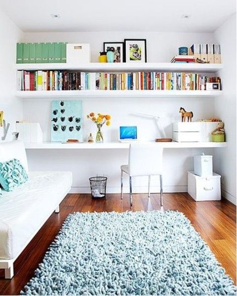 an airy and bright space with built-in shelves and a desk plus a small sofa to turn into a bed