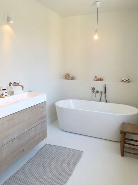 a modern white bathroom with a wooden vanity and a wooden stool