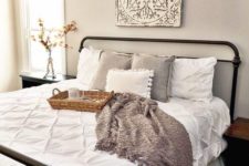 26 a cozy farmhouse style guest bedroom with an artwork and some baskets
