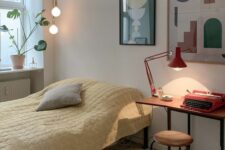 a Scandinavian guest bedroom with a bed with yellow bedding, a small desk, a stool, a mini gallery wall and some cool lamps