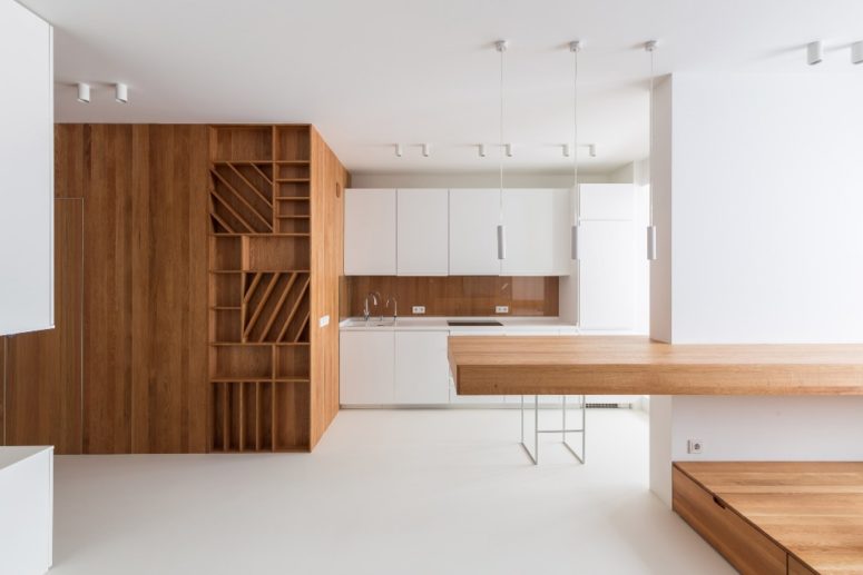 This ultra minimalist apartment is done of white and rich colored wood and features maximal functionality and the best organization of space