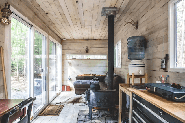 The cabin is clad with wood inside and there's a glazed wall with doors