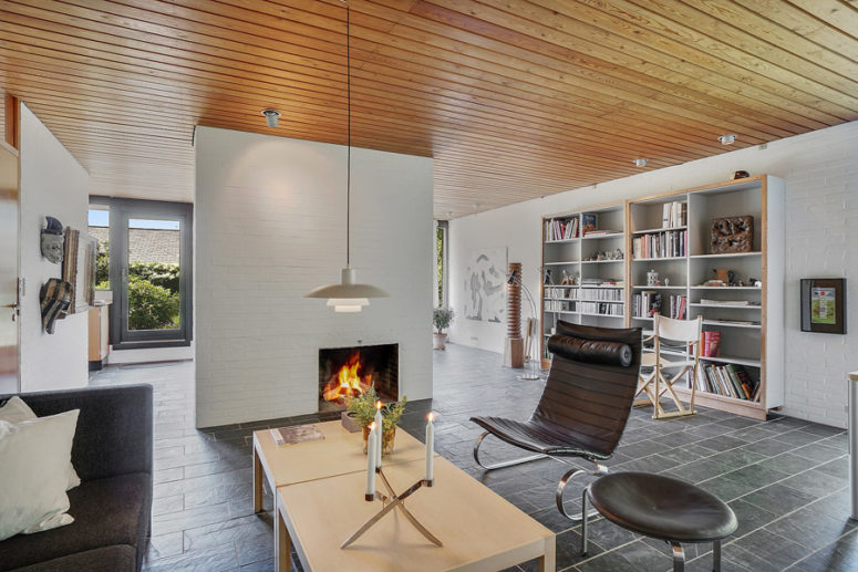 The living room is done with dark sititng furniture and light colored tables and bookcases, a fireplace adds coziness The living room is done with dark sititng furniture and light-colored tables and bookcases, a fireplace adds coziness