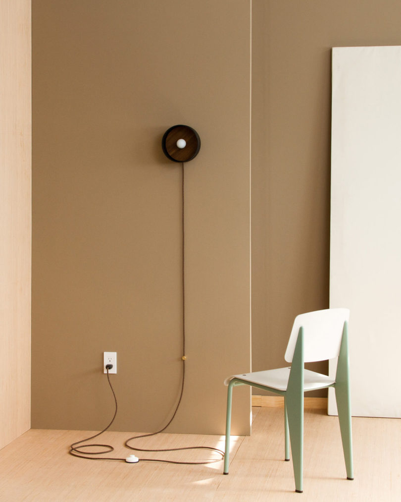 The piece features a wooden insert, a metal frame and thick cord that becomes part of the look