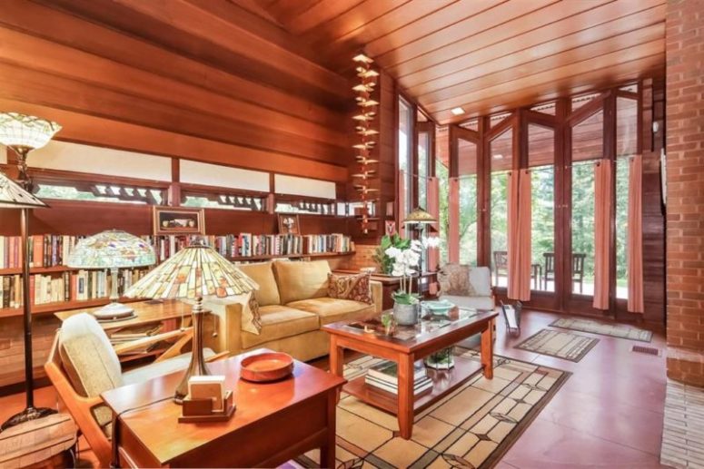 The living room features high ceilings, a glazed wall, lots of bookshelves and a selection of red wood furniture The living room features high ceilings, a glazed wall, lots of bookshelves and a selection of red wood furniture