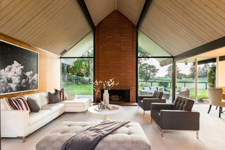 The living room is done with a glazed wall, a brick clad fireplace and a selection of comfortable and chic furniture The living room is done with a glazed wall, a brick clad fireplace and a selection of comfortable and chic furniture