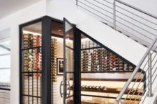 03 a cool modern under stairs wine cellar with lots of bottles on wall-mounted shelves and additional lights