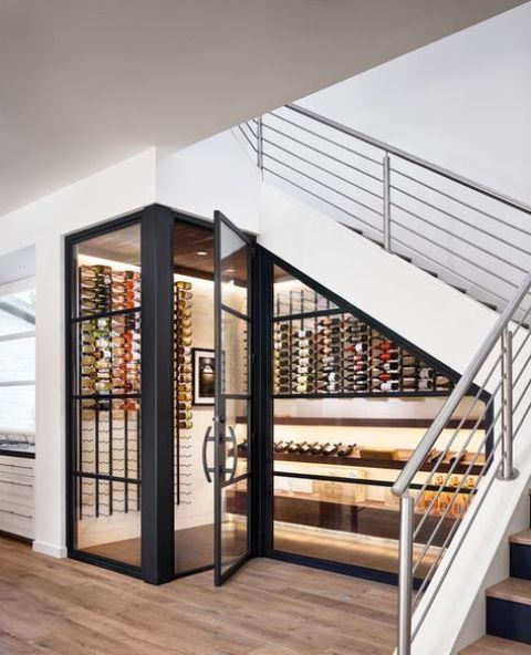 a cool modern under stairs wine cellar with lots of bottles on wall-mounted shelves and additional lights