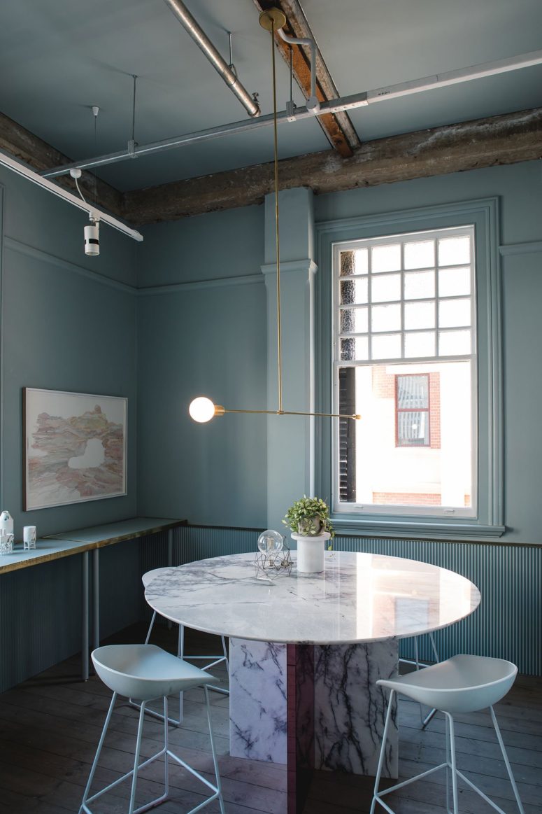 The dining space is done in pale green, with brass touches and highlighted industrial pipes