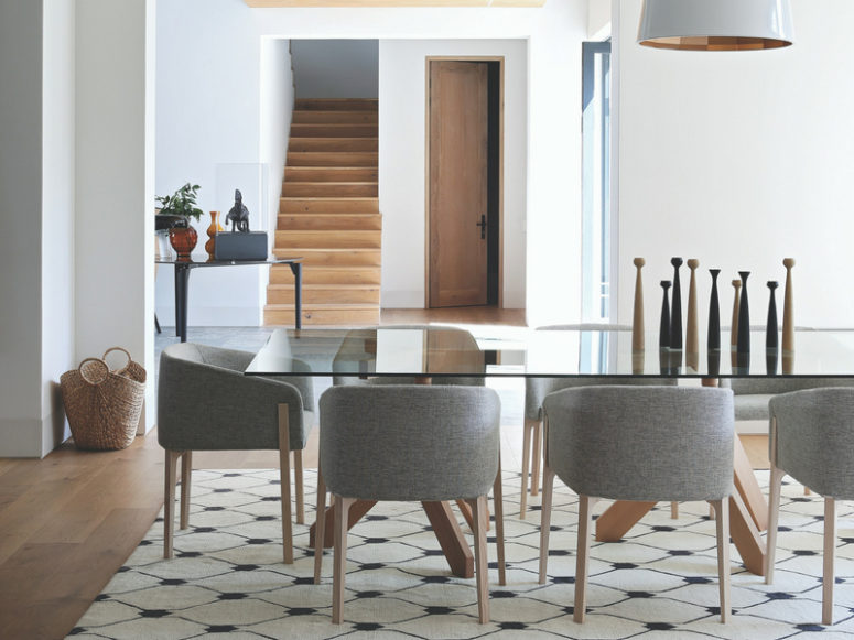 The dining space is done with a chic glass dining table and felt chairs, accessories here play an important role
