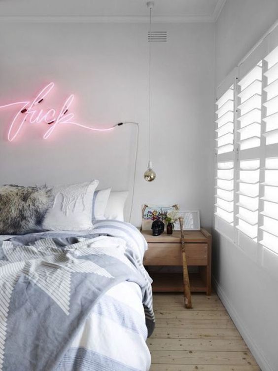 a daring neon light word will add a whimsy and fun touch to your bedroom