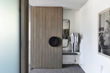 05 The front door is a statement piece clad with wide wooden planks and with a round knob