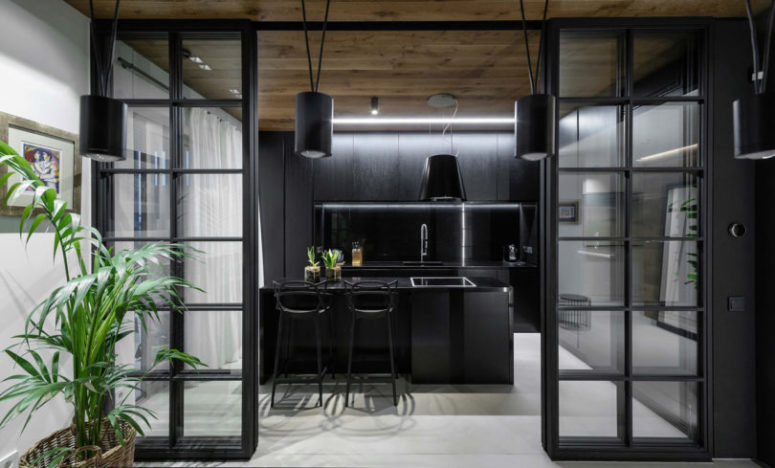 The kitchen is done with totally black cabinets and a large kitchen island with a breakfast nook