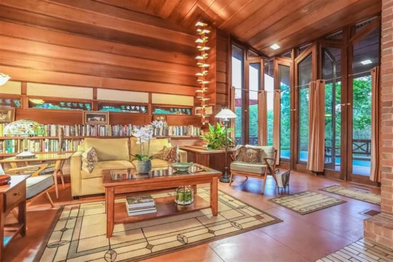 Horizontal redwood panels with red brick ad red tiles create a bold and warming up base for the living room