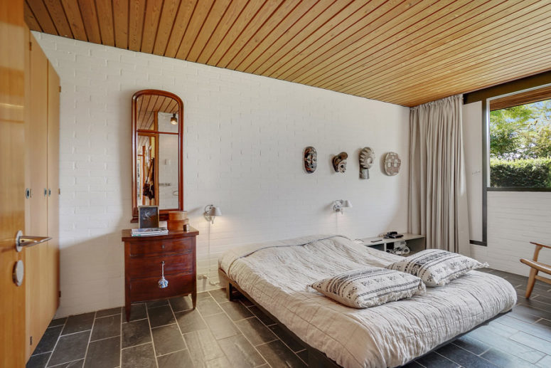 The master bedroom is done with a large bed, wardrobes, a dresser of redwood and somemasks on the wall The master bedroom is done with a large bed, wardrobes, a dresser of redwood and somemasks on the wall