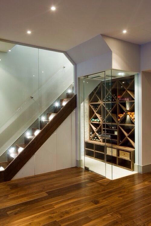 a modern wine cellar with glass walls and doors plus a large shelving unit for bottles