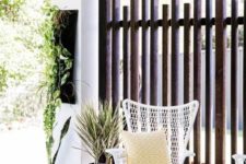 07 a vertical plank wooden screen is a chic idea for privacy and brings a relaxed feel to the space