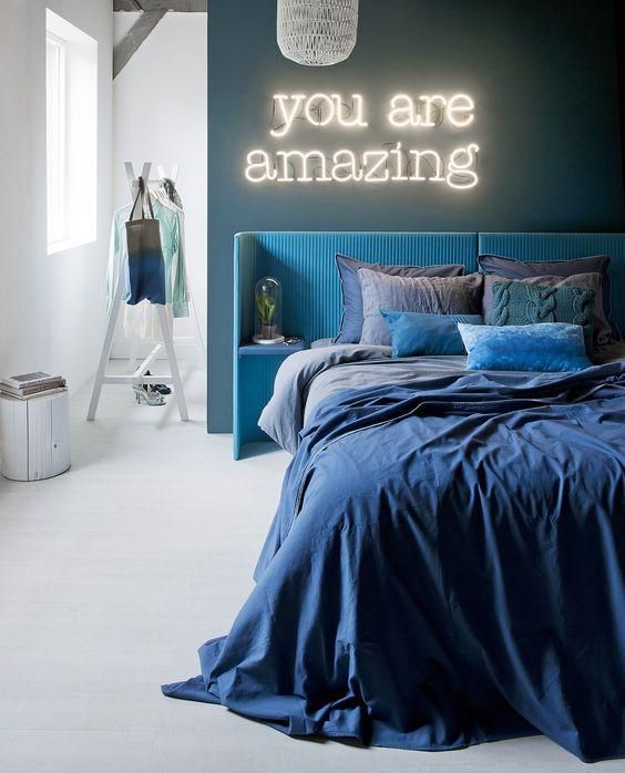to avoid a gloomy look in a blue and white bedroom, add a bright neon light over the bed