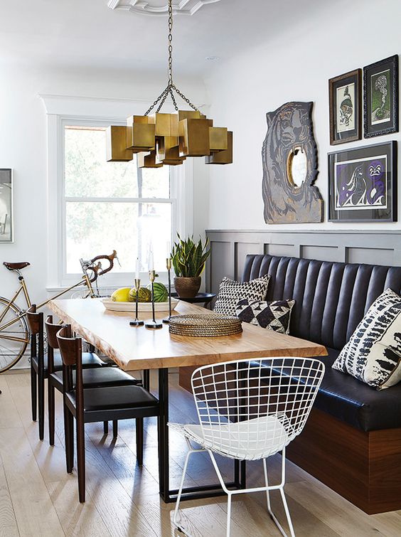 a modern dining area with a black leather banquette and a raw edge dining table
