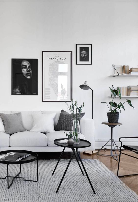 black framed asymmetrical gallery wall is highlighted with black legged furniture and surfaces