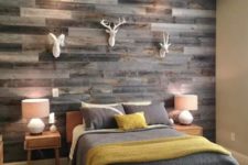 11 a rustic woodland guest bedroom with a weathered wood plank wall and faux taxidermy for creating an ambience