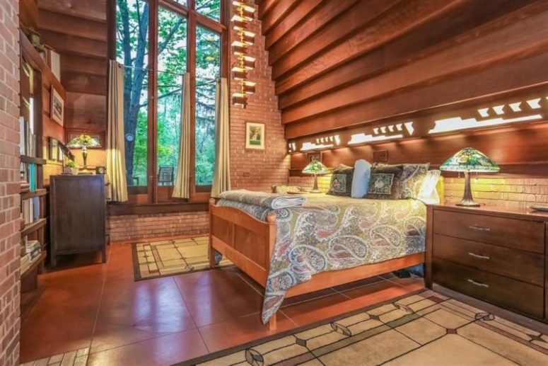 The bedroom is done with double height windows and a cool redwood panel wall, which acts as an art piece here