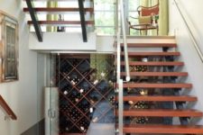 12 a stylish under the stairs wine cellar with glass doors and wooden shelves on the walls