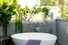 12 an outdoor deck with low walls all round to keep privacy yet have enough light, a stylish oval bathtub and lots of greenery